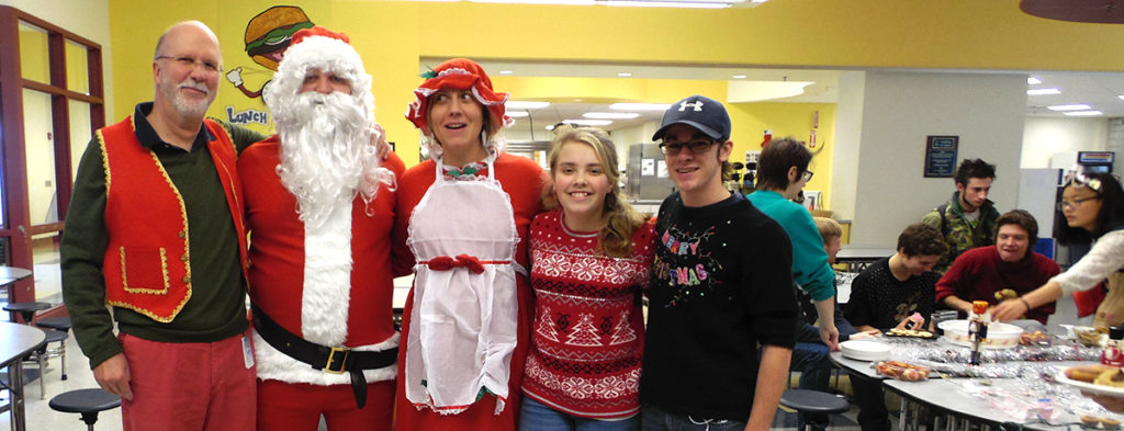 Featured image of article: Students In Ugly Sweaters Pose With Santa, Mrs. Claus